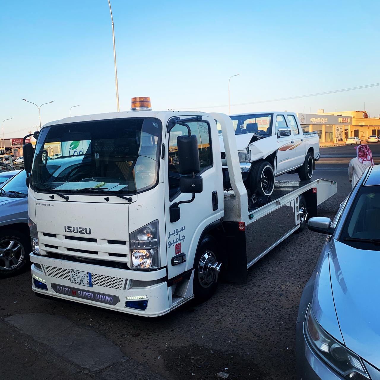 سطحة في الشارع تحمل سيارة بيك اب بيضاء